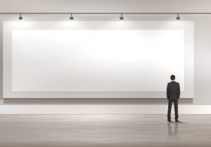 Business person standing near a blank billboard